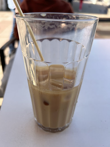 Glas Eiskaffee mit Strohhalm auf dem Tisch im Liquid Beans Café